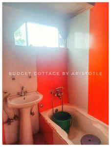 a bathroom with a sink and a tub and a toilet at Budget Cottage By Aristotle in Srinagar