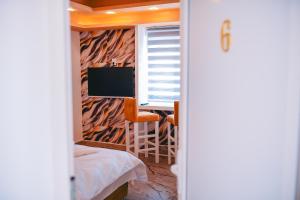 a bedroom with a desk and a computer in a window at Lux apartmani Savić in Aleksinac