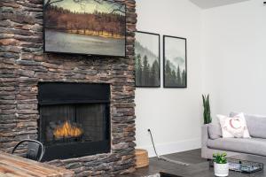 a living room with a stone fireplace with a tv at Cardinal On Main in Blowing Rock