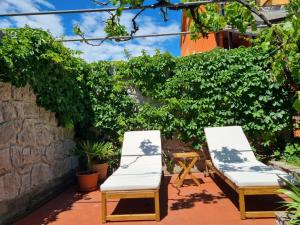 two chairs and a table on a patio at Holiday house Maja in Baška