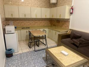 a small kitchen with a couch and a table at شاطئ الأحلام الحديث للشقق المخدومة in Taif