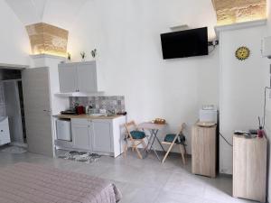 a room with a kitchen with a bed and a table at Monolocale Central Station in Brindisi