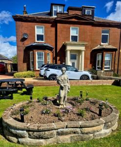 a statue in a garden in front of a house at Ta'Pinu House and Spa in Horse Isle