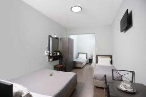 a bedroom with two beds and a table and a tv at Soluna Studios in Polychrono
