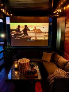 a living room with a couch and a large screen at Aqua Vita Concept in Bihać