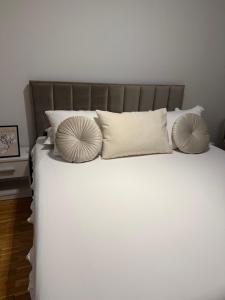 a bed with white sheets and pillows on it at Rosabell in Imotski