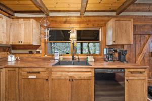 a kitchen with wooden cabinets and a sink at Creekside Cabin in Blowing Rock +24 photos