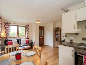 a kitchen and living room with a table and a couch at Orchard Cottage in Ledbury