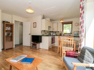 a living room with a table and a kitchen at Orchard Cottage in Ledbury +23 photos