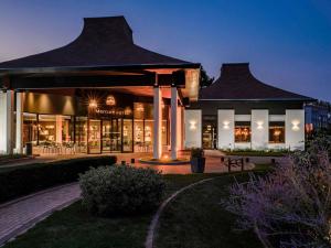 a lit up building with a building with at Mercure Lille Marcq en Baroeul in Marcq-en-Baroeul