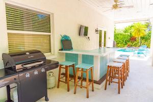 a kitchen with a bar with stools and a grill at White Shell in Anna Maria