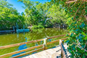 a body of water with a wooden fence and trees at White Shell in Anna Maria +23 photos