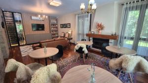 a living room with tables and chairs and a couch at Malbec Casa Hotel in Bento Gonçalves