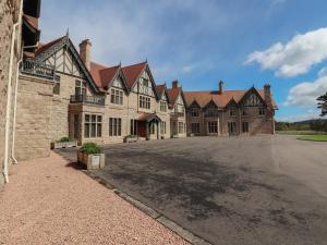 a large brick building with a parking lot at Bynack - Mar Lodge Estate in Ballater