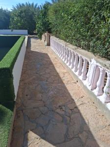 a stone walkway with a white fence next to a pool at Ksour tataouine in Qaşr al Muqābilah