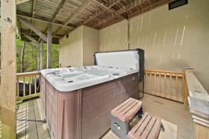 a large bath tub sitting on a balcony with a bench at Riverside Mountain Retreat in Boone