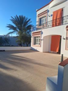 a house with a palm tree in the background at Ksour tataouine in Qaşr al Muqābilah