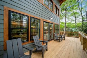 a deck with chairs and windows on a house at Appalachian Cottage in Blowing Rock