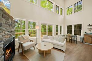 a living room with white furniture and a fireplace at Appalachian Cottage in Blowing Rock