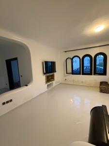 a room with a white floor and three windows at Soumaya plage appartement in Fnidek