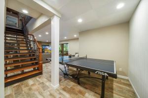 a ping pong table in a room with a staircase at Lake Hills Hideaway in Wilkesboro