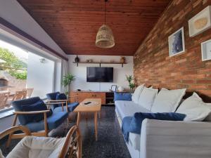 a living room with blue and white furniture and a brick wall at Holiday house Maja in Baška