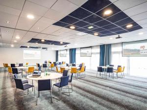 a conference room with tables and chairs and a projection screen at Novotel Beaune in Beaune +233 photos