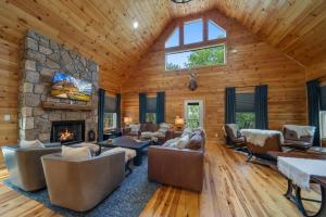 a log home living room with a stone fireplace at Pine Ridge Retreat in Beech Mountain