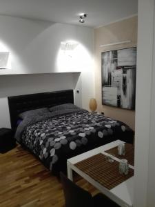 a bedroom with a black and white bed and a table at B&B Stazione Latina in Sermoneta