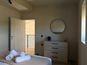 a bedroom with a bed with a mirror and a dresser at ZOSANA Villa in Kallithea Halkidikis +23 photos