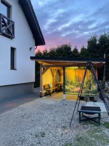 a porch of a house with a swing at Apartament Pod Skarpą z balią Wieżyca in Szymbark