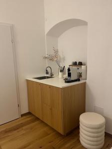 a kitchen with a counter with a sink and a stool at room4you Lambach Apartment, Studiozimmer & Zimmer in Lambach