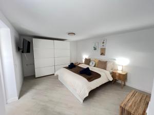 a white bedroom with a large bed and a table at Gratitud Un refugio con encanto in Soo