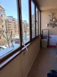 a room with a window with a view of a snow covered yard at Apatement de luxe in Roşu