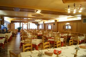 a dining room with white tables and yellow chairs at Hotel Milano in Asiago
