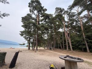 a sandy beach with trees and a table on it at Studio yvonand in Yvonand +13 photos