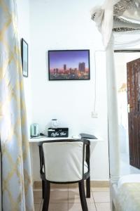 a table and a chair in a room with a tv at Cosy Garner Haven Watamu in Watamu