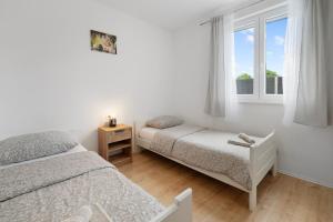a bedroom with two beds and a window at Apartmani Rialto in Kakma +36 photos