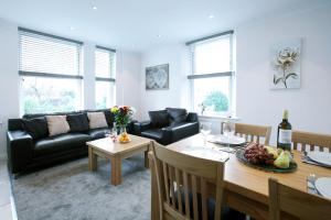 uma sala de estar com uma mesa e um sofá em Austens Apartments em Torquay
