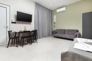 a living room with a couch and a table and chairs at United Cretan Villas Boutique Studio in Agia Marina Nea Kydonias