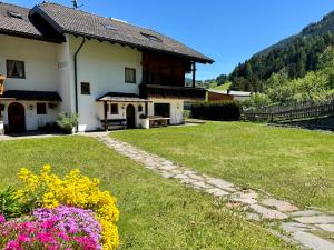 a house with a lawn and flowers in front of it at Apartments Silvonia in Pallua