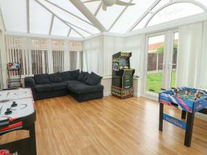 a living room with a couch and a video game at 9 Beckett Close in Colwyn Bay