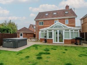 a house with a conservatory and a grill in a yard at 9 Beckett Close in Colwyn Bay