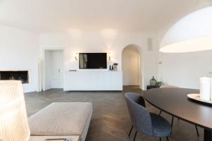a living room with a table and a tv at Uno - Via Loveno, Menaggio by LoveComo in Menaggio