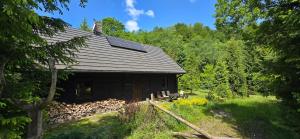 an old cabin with solar panels on the roof at KURNACHATA in Wetlina