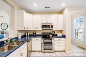 a kitchen with white cabinets and a sink at Bear Trap Dunes - 60F October Glory in Ocean View +35 photos