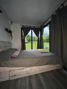 a bedroom with a large bed with a window at OffGrid Retreat Rtanj in Boljevac +4 photos