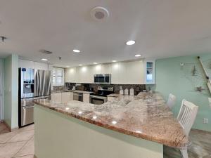 a large kitchen with a large marble counter top at Oceanside Retreat 804 in Ormond Beach +13 photos