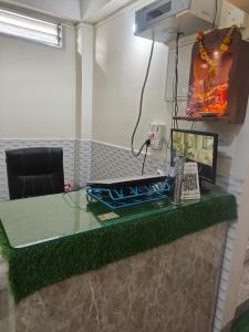 a desk with a glass top with a computer on it at Beaumun Homestay in Bāghdogra