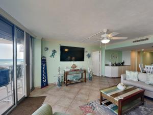 a living room with a couch and a flat screen tv at Oceanside Retreat 804 in Ormond Beach